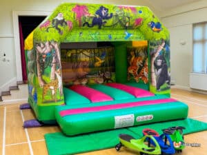 A vibrant bouncy castle featuring a jungle theme, complete with animal illustrations, ideal for kids' playtime.
