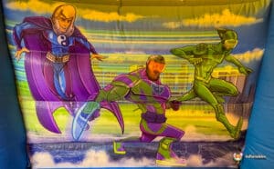 A colourful inflatable backdrop featuring three superhero characters in dynamic poses, set against a city skyline and vibrant sky.