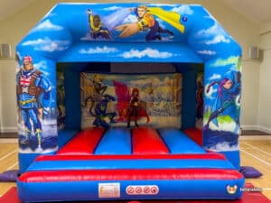 A playful hero-themed bouncy castle in red and blue, ideal for birthday parties.