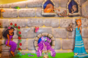 A vibrant bouncy castle resembling a princess castle, with a princess and her dragon enjoying their time together.