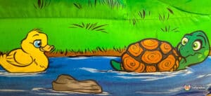 A playful cartoon turtle and duck swimming side by side in a sunny pool.