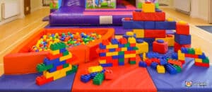 A fun play area equipped with a slide, bouncy castle, inflatable play equipment, and colorful building bricks for kids.