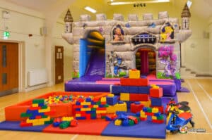A children's play area designed like a castle, complete with a bouncy castle and a slide for active play.
