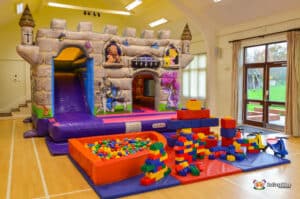 A castle-inspired play area with a bouncy castle and slide, evoking a medieval atmosphere for children.