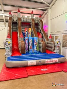 A vibrant inflatable shaped like a castle, complete with a turreted top for kids to enjoy sliding down.