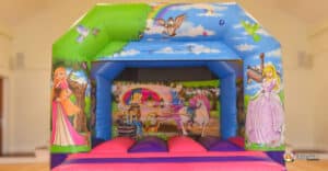 A whimsical bouncy castle decorated with princess illustrations, designed for children's enjoyment at a party or event.