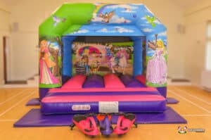 A cheerful bouncy castle showcasing princess designs, providing a fun play area for kids at a celebration.