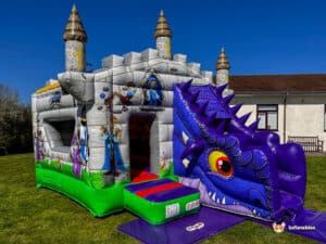 A colorful inflatable castle with a dragon-themed slide, featuring cartoon characters, towers, and a vibrant green base on a sunny day.
