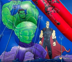 A vibrant inflatable featuring iconic characters, including a muscular green superhero and a hero in a black and red costume.