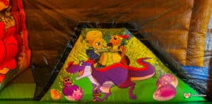Colorful inflatable artwork features a boy riding a purple dinosaur, accompanied by a small creature and colorful dinosaur eggs.