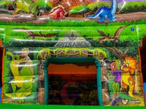 Colorful dinosaur-themed inflatable with cartoon characters exploring nature, featuring a vibrant entrance and playful prehistoric creatures.