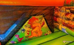 Colorful inflatable bounce house interior featuring a boy with binoculars and friendly dinosaurs. Bright, fun designs for children's entertainment.