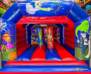 Front view of the inflatable bouncy castle showing the interior with two punching pillars decorated as monster characters, surrounded by bright red and blue vinyl