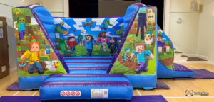 Frontal view of the blue and purple Minecraft Bounce and Slide inflatable, showcasing the blocky character artwork on both the front columns and the main group scene on the back wall.
