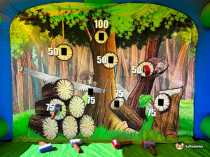 The back wall of the inflatable game with several foam padded axes stuck to the high-scoring target zones.