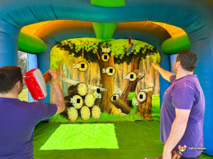 Shot of a foam axe sticking to a high-scoring target on a tree trunk mural, while a participant follows through with their throwing motion.