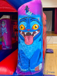 Close-up of a side pillar featuring a large blue monster cat with a bird on its head.