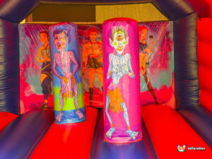 Interior view of the bouncer showing two purple vertical obstacles printed with one-eyed monsters.