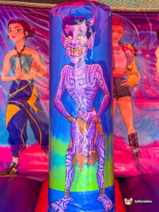 Close-up of a vertical biff-bash obstacle printed with a purple demon character.
